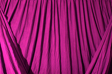 Image showing Draped black background cloth lit with pink gel