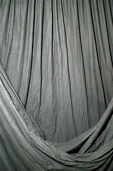 Image showing Draped black background cloth lit with green gel