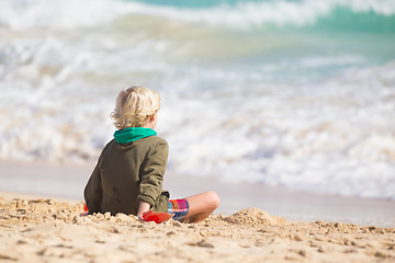 Image showing Boy playing with toys on beach.