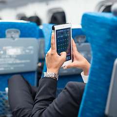 Image showing Businessman using tablet phone on airplane.