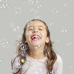 Image showing Girl playing with soap bubbles