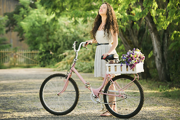 Image showing Happy girl with her bicycle