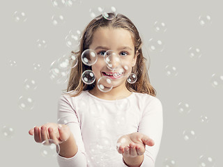 Image showing Girl playing with soap bubbles