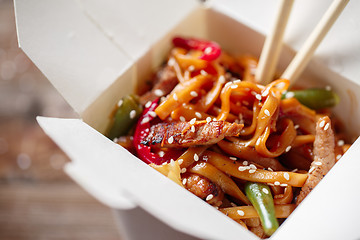 Image showing Noodles with pork and vegetables in take-out box on wooden table