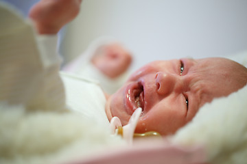 Image showing Beautiful newborn baby crying in his bed