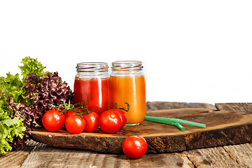 Image showing The bottles with fresh vegetable juices on wooden table