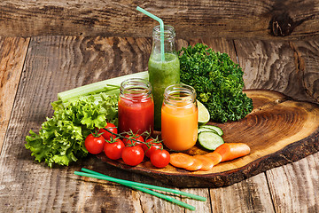 Image showing The bottles with fresh vegetable juices on wooden table