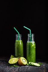 Image showing The bottles with fresh vegetable juices on wooden table