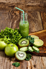 Image showing The bottles with fresh vegetable juices on wooden table