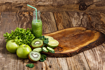 Image showing The bottles with fresh vegetable juices on wooden table