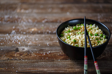 Image showing Bowl of noodles with fresh peas and chopped onion.