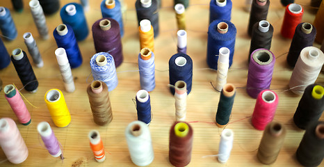 Image showing Sewing threads arranged on wooden board