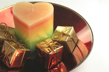 Image showing heart candle and presents in a red glass bowl