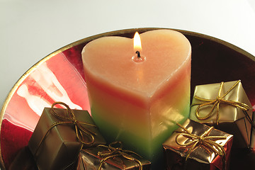 Image showing heart candle and presents in a red glass bowl