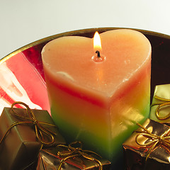 Image showing heart candle and presents in a red glass bowl
