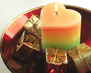 Image showing heart candle and presents in a red glass bowl