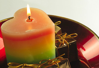 Image showing heart candle and presents in a red glass bowl