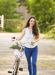 Image showing Girl with her bicycle