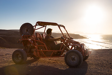 Image showing Man driving quadbike in sunset.