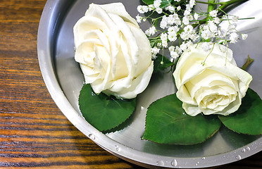 Image showing Beautiful rose on the surface of the vessel with water.