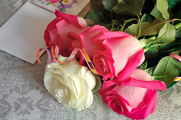 Image showing A bouquet of roses and a letter of congratulation.