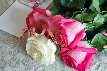 Image showing A bouquet of roses and a letter of congratulation.