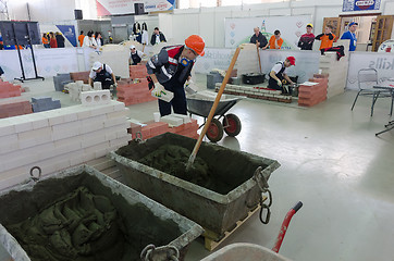 Image showing Young bricklayers perform a task of competition