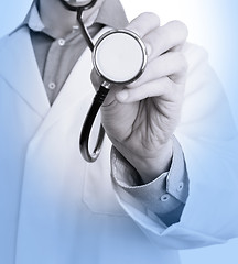 Image showing Close up of a Doctor\'s hand, holding a stethoscope, medical blue