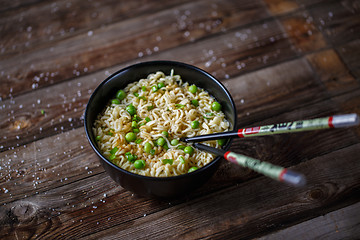 Image showing Bowl of noodles with fresh peas and chopped onion.