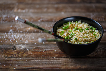 Image showing Bowl of noodles with fresh peas and chopped onion.