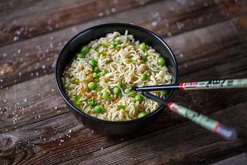 Image showing Bowl of noodles with fresh peas and chopped onion.