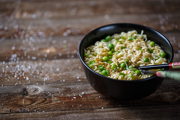 Image showing Bowl of noodles with fresh peas and chopped onion.