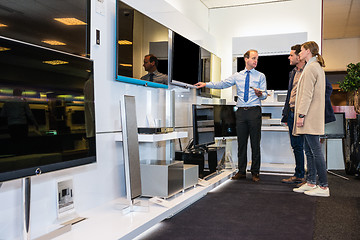 Image showing Salesman Showing Flat Screen Tv To Couple In Store