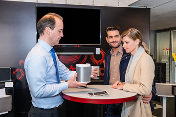Image showing Assistant Showing Compact Speaker To Couple In Shop