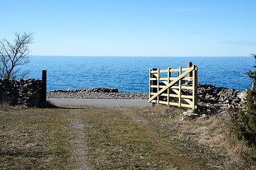 Image showing Open traditional wooden gate by the coast