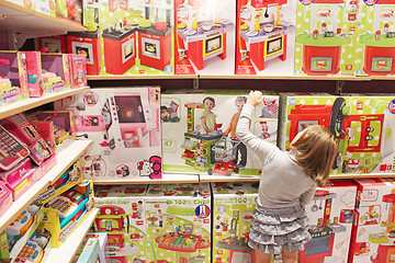 Image showing Girl chooses a toy in a toy shop