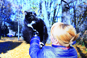 Image showing woman with black cat in the autumn park