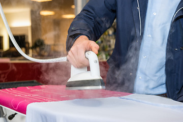 Image showing Man Testing Steam Iron Before Buying From Hypermarket