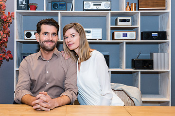 Image showing Happy Couple At Counter Against Shelves With Speakers At Shop