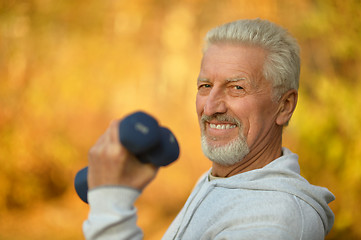 Image showing Elderly man exercising with dumbbells