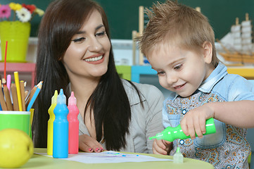 Image showing little boy drawing  with mother