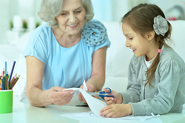 Image showing Grandmother with granddaughter cutting together