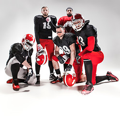 Image showing The five american football players posing with ball on white background