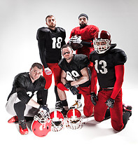 Image showing The five american football players posing with ball on white background