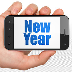 Image showing Entertainment, concept: Hand Holding Smartphone with New Year on display