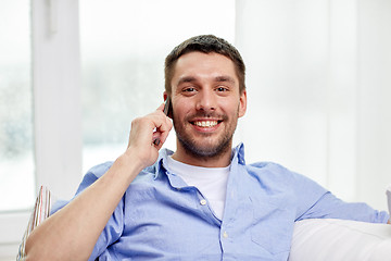 Image showing happy man calling on smartphone at home