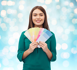 Image showing smiling young woman with color swatches