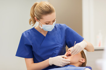 Image showing female dentist checking patient girl teeth