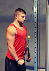 Image showing man flexing muscles on cable machine gym