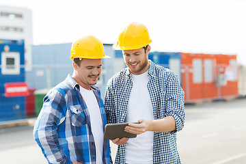 Image showing two smiling builders in hardhats with tablet pc